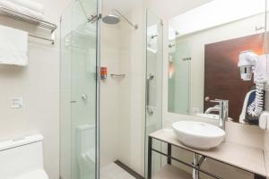a bathroom with a sink and a glass shower at Casa Andina Standard Cusco San Blas in Cusco