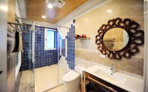 La salle de bains est pourvue d'un lavabo, d'un miroir et de toilettes. dans l'établissement Sunny Lucy, à Lugu