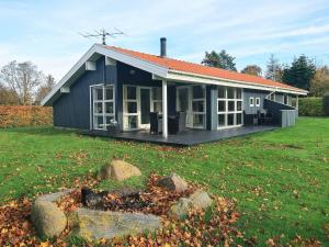 a blue house with a large yard with rocks at Three-Bedroom Holiday home in Hemmet 30 in Humble