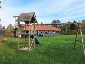 a playground with a swing set in a yard at Three-Bedroom Holiday home in Hemmet 30 in Humble