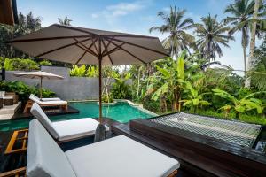 un patio al aire libre con sombrilla y piscina en Villa Hammock by BaliSuperHost, en Ubud