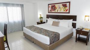 a bedroom with a large bed and a telephone at Hotel Arhuaco Rodadero in Santa Marta