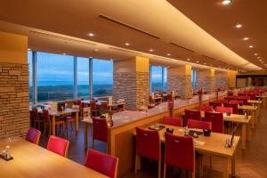 旭市にある亀の井ホテル 九十九里のテーブルと椅子、窓のあるレストラン
