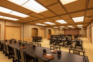 a large room filled with tables and chairs at KAMENOI HOTEL Kujukuri in Asahi