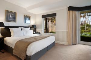 a bedroom with a large bed and a window at Echoes Boutique Hotel & Restaurant Blue Mountains in Katoomba