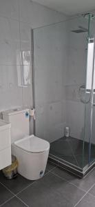 a bathroom with a shower and a white toilet at Stunning Stay In Papatoetoe Auckland in Auckland