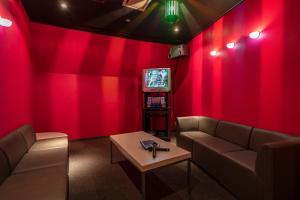 a red room with a couch and a tv at KAMENOI HOTEL Kujukuri in Asahi