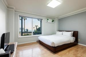 西歸浦的住宿－Euro House，一间卧室设有一张床和一个大窗户