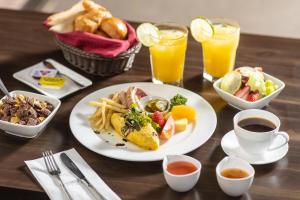 a table with a plate of breakfast food and drinks at Kensington Resort Gapyeong in Gapyeong