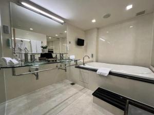 a bathroom with a tub and a large mirror at Resorts World Genting - Genting Grand in Genting Highlands