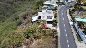 a house on a hill next to a road at Eagles Nest Residence - Apartment 2 in Rodrigues Island
