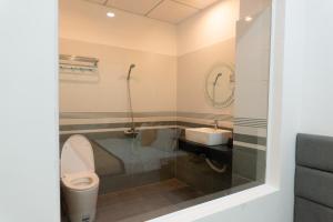 a bathroom with a toilet and a sink at Khang Hy Hotel in Buôn Enao