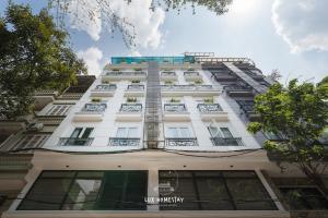 a tall white building with a lot of windows at Lux Westlake Studio in Hanoi