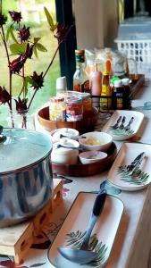 uma mesa com pratos e colheres em cima em Lys I dalen resort&camping em Khao Kho