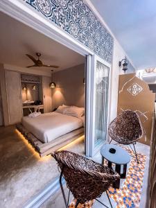 a bedroom with a bed and a chair at Layla Tulum - Adults Only in Tulum