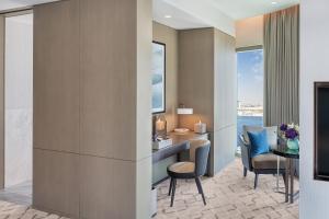 um quarto de hotel com uma secretária, cadeiras e uma mesa em Address Grand Creek Harbour em Dubai