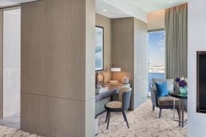 a hotel room with a desk and chairs and a table at Address Grand Creek Harbour in Dubai