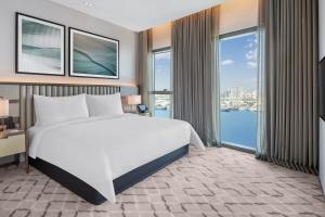 a bedroom with a large bed and large windows at Address Grand Creek Harbour in Dubai