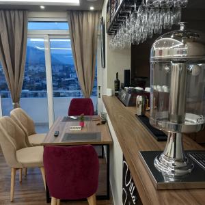 una cucina con bancone, tavolo e sedie di Vladimir Estate Hotel a Gjirokastër
