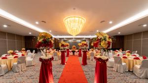 Travelodge Ipoh في ايبوه: قاعة احتفالات مع طاولات وكراسي وسجادة حمراء