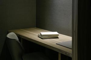 a desk with a book on top of it at Autumn Willow Hotel in Taichung