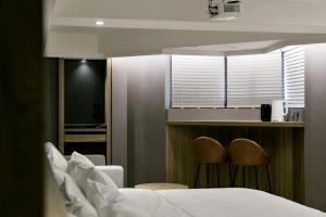 una camera d'albergo con un letto e due sedie di Autumn Willow Hotel a Taichung