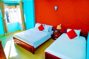 a bedroom with two beds with red and blue walls at Central Beach Hotel in Da Nang