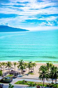 a view of a beach with palm trees and the ocean at Central Beach Hotel in Da Nang