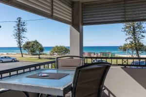 einen Tisch und Stühle auf einem Balkon mit Blick auf den Strand in der Unterkunft Beachfront MIAMI 2 Bdr Easy Living VIEWS VIEWS!!!! in Gold Coast