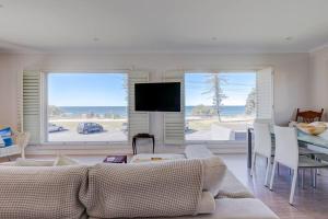 Beachfront MIAMI 2 Bdr Easy Living VIEWS VIEWS!!!! في غولد كوست: غرفة معيشة بها أريكة وطاولة وتلفزيون
