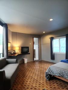 ein Wohnzimmer mit einem Bett und einem Sofa in der Unterkunft Petit Suncliff Resort in Haad Rin