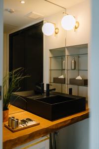 La salle de bains est pourvue d'un lavabo noir et d'un miroir. dans l'établissement HOTEL Inc, à Kyoto