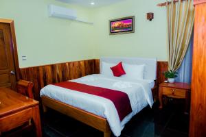 una camera da letto con un letto grande con cuscini rossi di Mohasal Angkor Boutique a Siem Reap Altre 16 foto