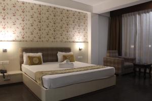 a bedroom with a large bed and a chair at Palri Boutique Hotel in Gangtok