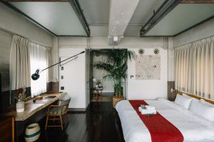 een slaapkamer met een groot bed en een bureau bij HOTEL Inc in Kyoto