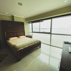 1 dormitorio con cama y ventana grande en 5-luxury suite Riverfront Vista al río, en Guayaquil