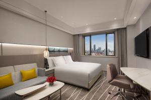 上海市にあるCrowne Plaza Shanghai Nanjing Road by IHGのベッドとソファのあるホテルの部屋