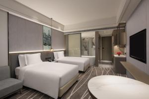 pokój hotelowy z dwoma łóżkami i telewizorem w obiekcie Crowne Plaza Shanghai Nanjing Road, an IHG Hotel w Szanghaju