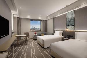 上海市にあるCrowne Plaza Shanghai Nanjing Road by IHGのベッド2台と薄型テレビ付きのホテルの部屋