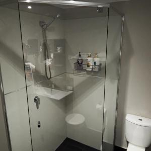 a bathroom with a shower and a toilet at Margaret River Mainstreet Apartment in Margaret River Town