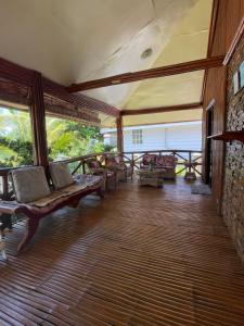 a screened in porch with couches and windows at West Sahara Beach House in Cabangan