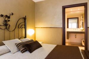 a bedroom with a large bed and a mirror at Hotel Els Caçadors de Ribes in Ribes de Freser