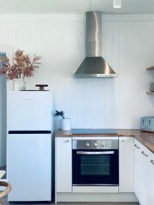 eine Küche mit einem weißen Kühlschrank und einem Herd in der Unterkunft Sweet Tide O Moyne in Port Fairy