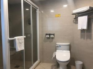 a bathroom with a toilet and a glass shower at Unite Hotel in Taipei