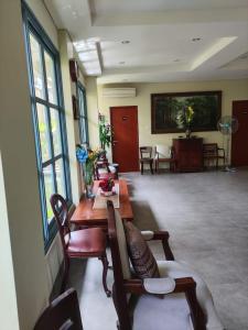 uma sala de estar com uma mesa, cadeiras e janelas em Rumah Pondok Pinang em Jakarta