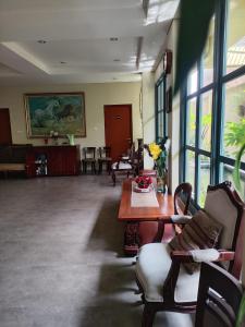 uma sala de estar com uma mesa, cadeiras e janelas em Rumah Pondok Pinang em Jakarta