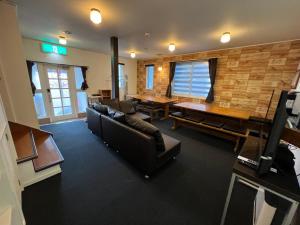 a living room with couches and a dining room table at TaoTechHOUSE in Hakuba