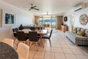 Una sala de estar con una mesa y sillas y un sofá. en Hibiscus Apartments on Hamilton Island by HIHA, en Hamilton Island