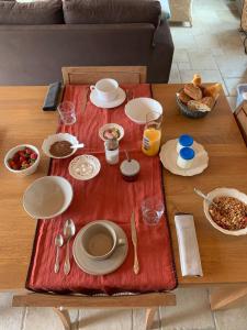 een tafel met een rode tafeldoek met eten erop bij Chambres d'hôtes LES CHENES VERTS in Le Grand Vieil