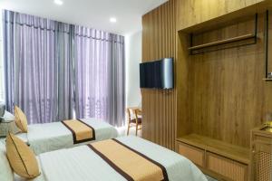 Habitación de hotel con 2 camas y TV de pantalla plana. en Khang Hy Hotel en Buôn Enao